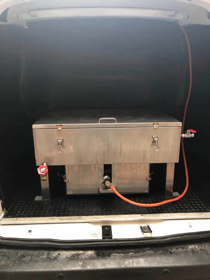 An oven cleaning tank loaded in the back of a van
